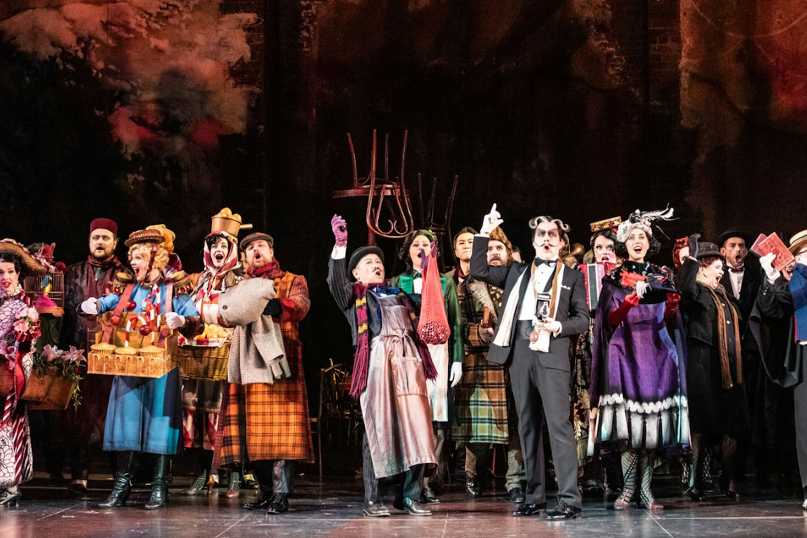 Performers on stage during a scene from La Bohème opera.