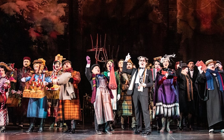 Performers on stage during a scene from La Bohème opera.