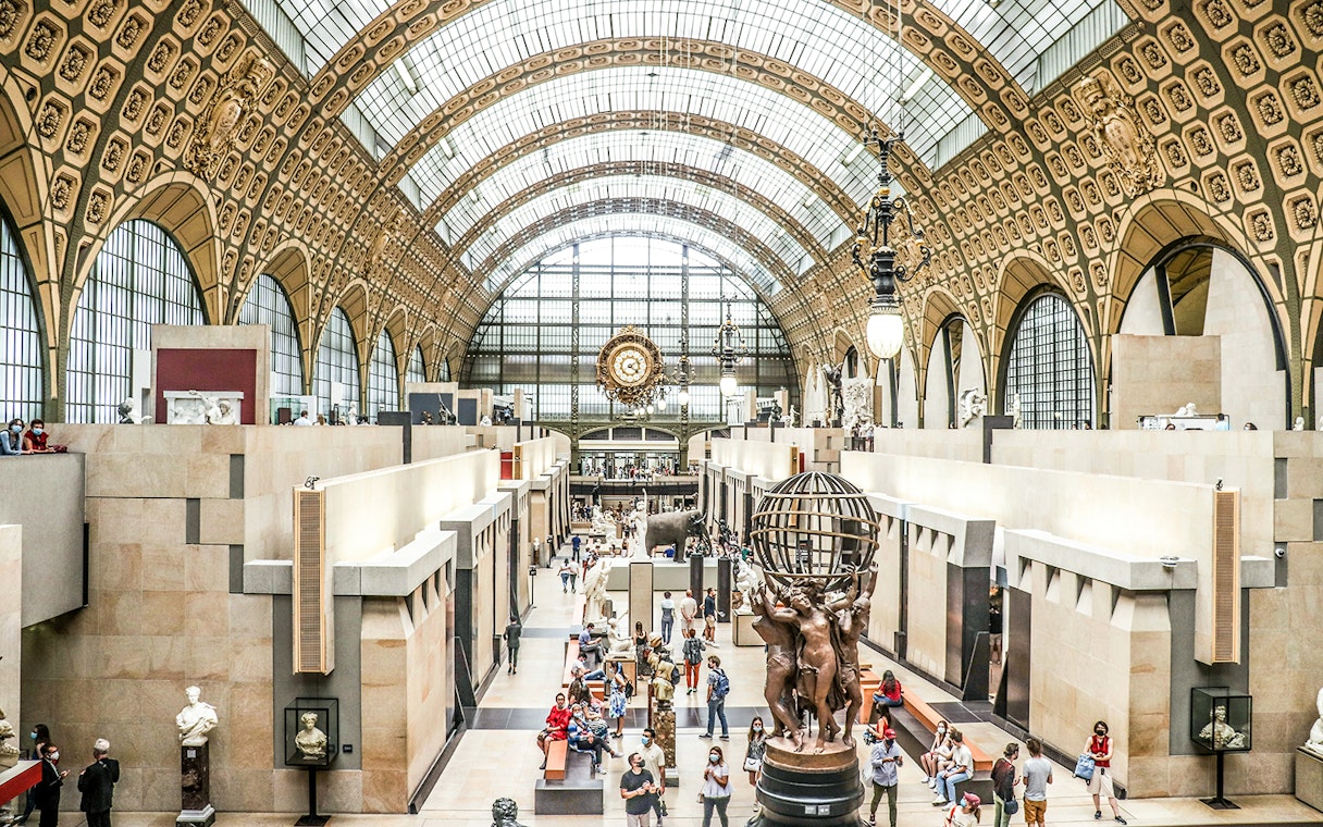 Orsay Museum interior with sculptures and visitors at a temporary exhibition in Paris.