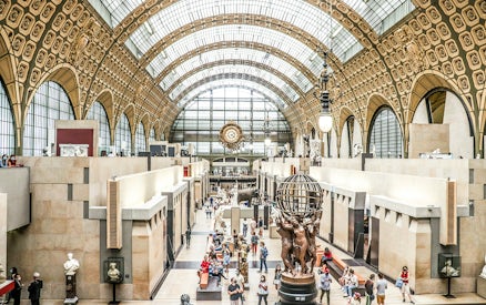 Orsay Museum interior with sculptures and visitors at a temporary exhibition in Paris.