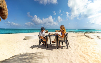 Visitors dining on the beach at National Park of Puerto Morelos, Mexico.