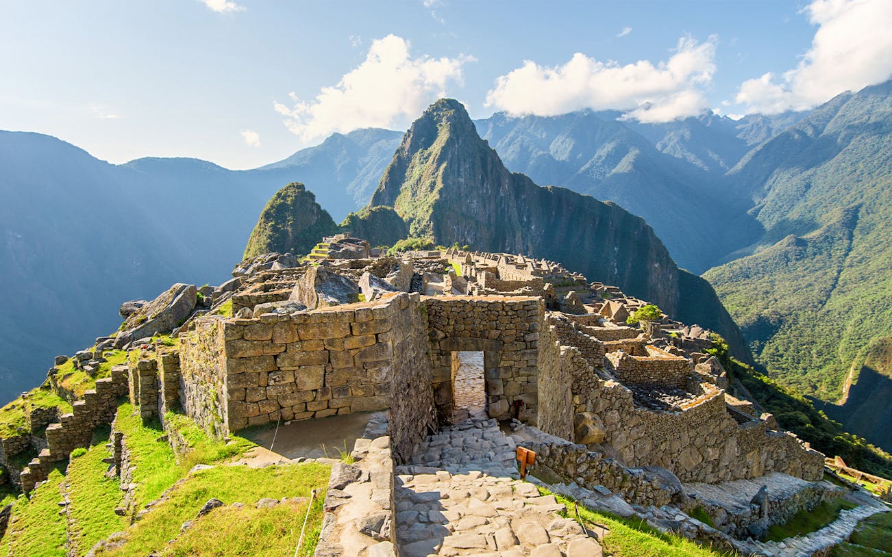 Main entrance gate to Machu Picchu with stone ruins and mountain backdrop.