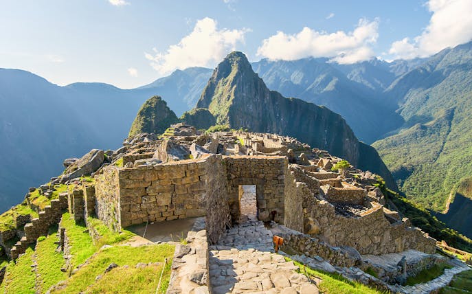 Main entrance gate to Machu Picchu with stone ruins and mountain backdrop.