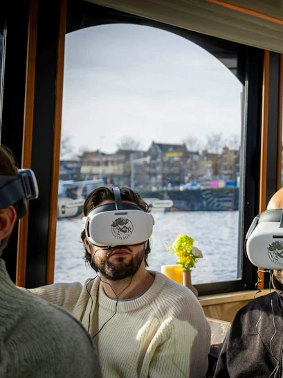 Guests experiencing 17th Century Amsterdam VR Canal Cruise with headsets.