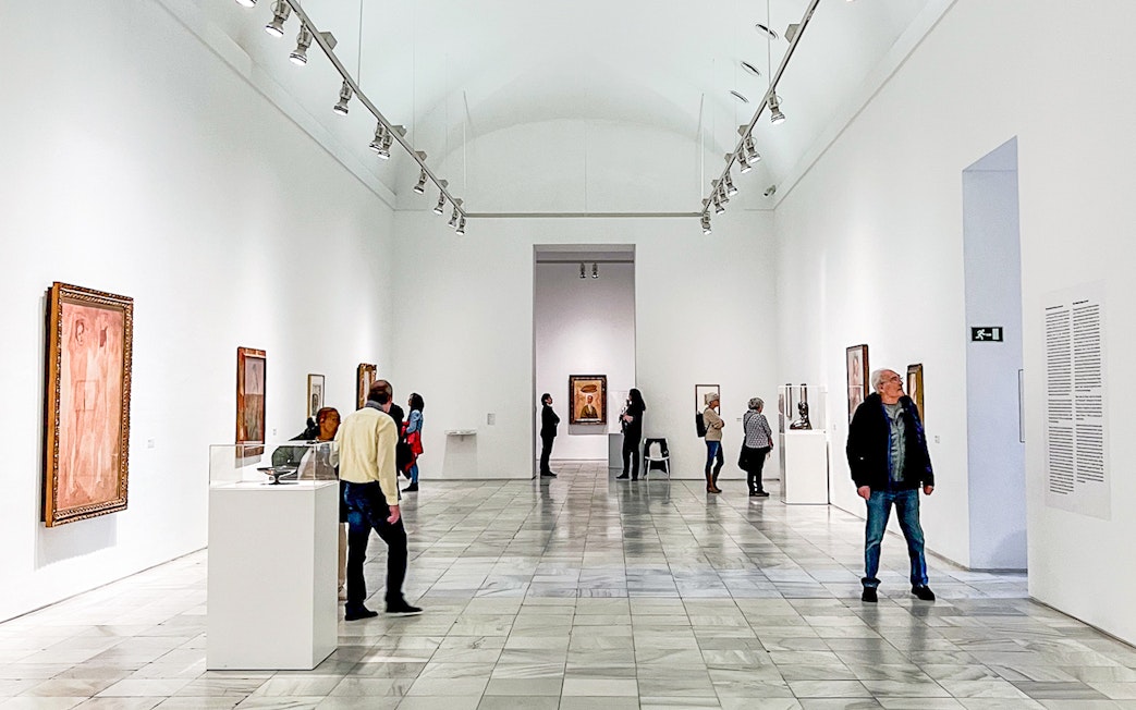 Visitors exploring art exhibits at Reina Sofia Museum in Madrid.