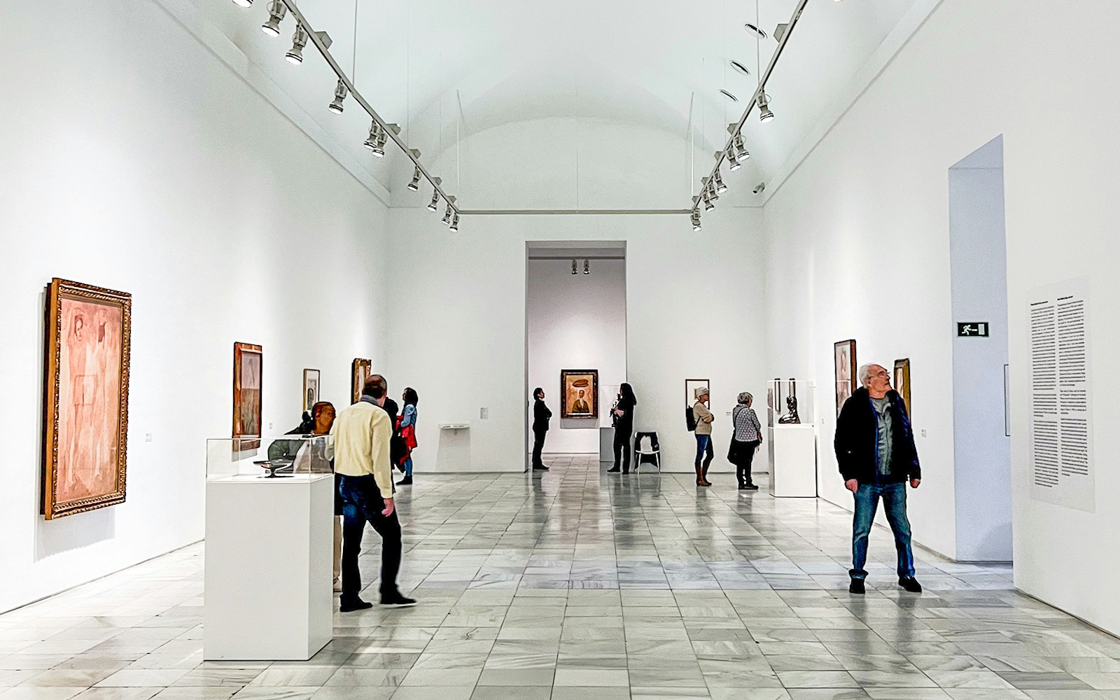 Visitors exploring art exhibits at Reina Sofia Museum in Madrid.