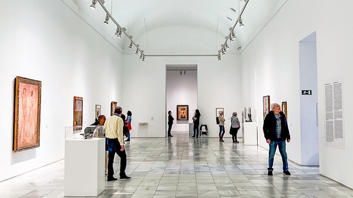 Guide leading a group on a Reina Sofia Museum tour, showcasing modern art in a spacious gallery