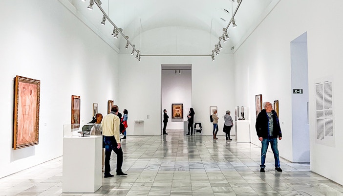 Visitors exploring art exhibits at Reina Sofia Museum in Madrid.