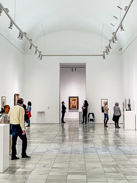 Visitors exploring art exhibits at Reina Sofia Museum in Madrid.