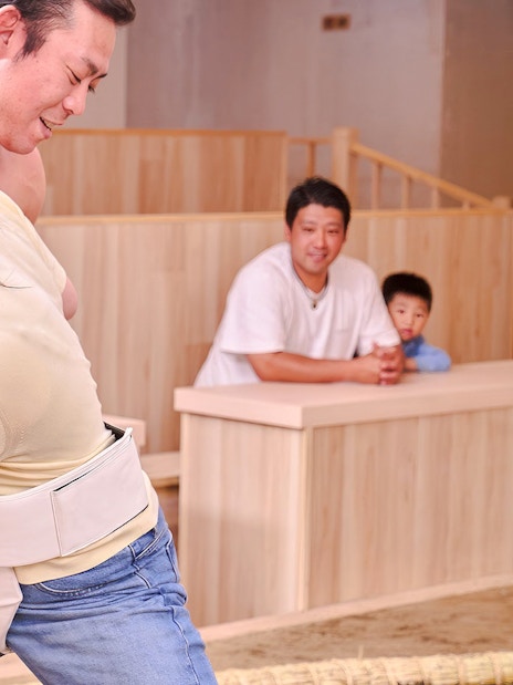 Tourist wrestling with sumo wrestler at Ryogoku Sumo Show, Tokyo.