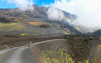 Visitors trekking near Mount Etna's summit on a guided tour.