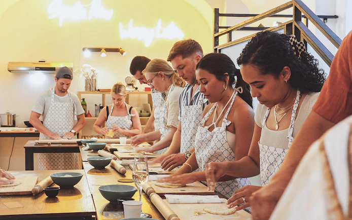 Participants making pasta at a cooking class in Italy.