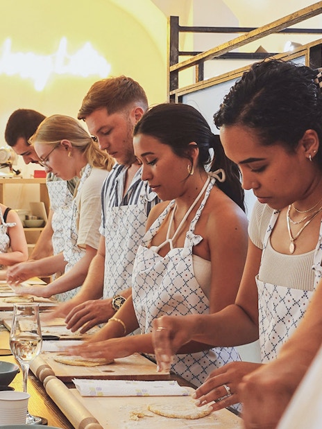 Participants making pasta at a cooking class in Italy.
