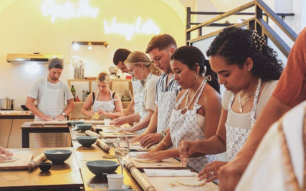 Participants making pasta at a cooking class in Italy.
