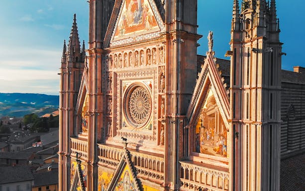 Orvieto Cathedral facade with intricate carvings and rose window, Italy.