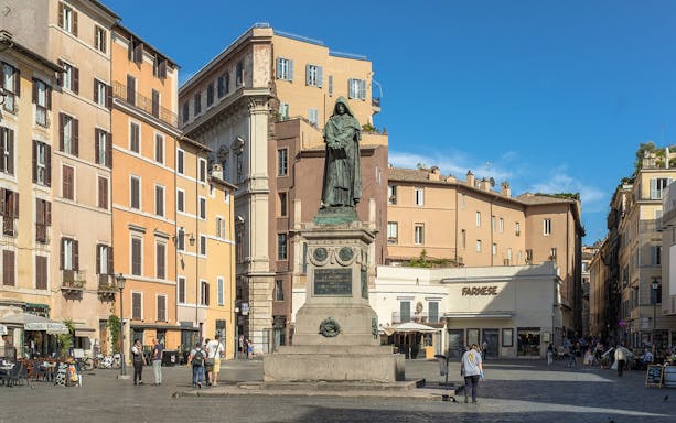 Statue of Giordano Bruno in Campo de Fiori, Rome, surrounded by historic buildings.