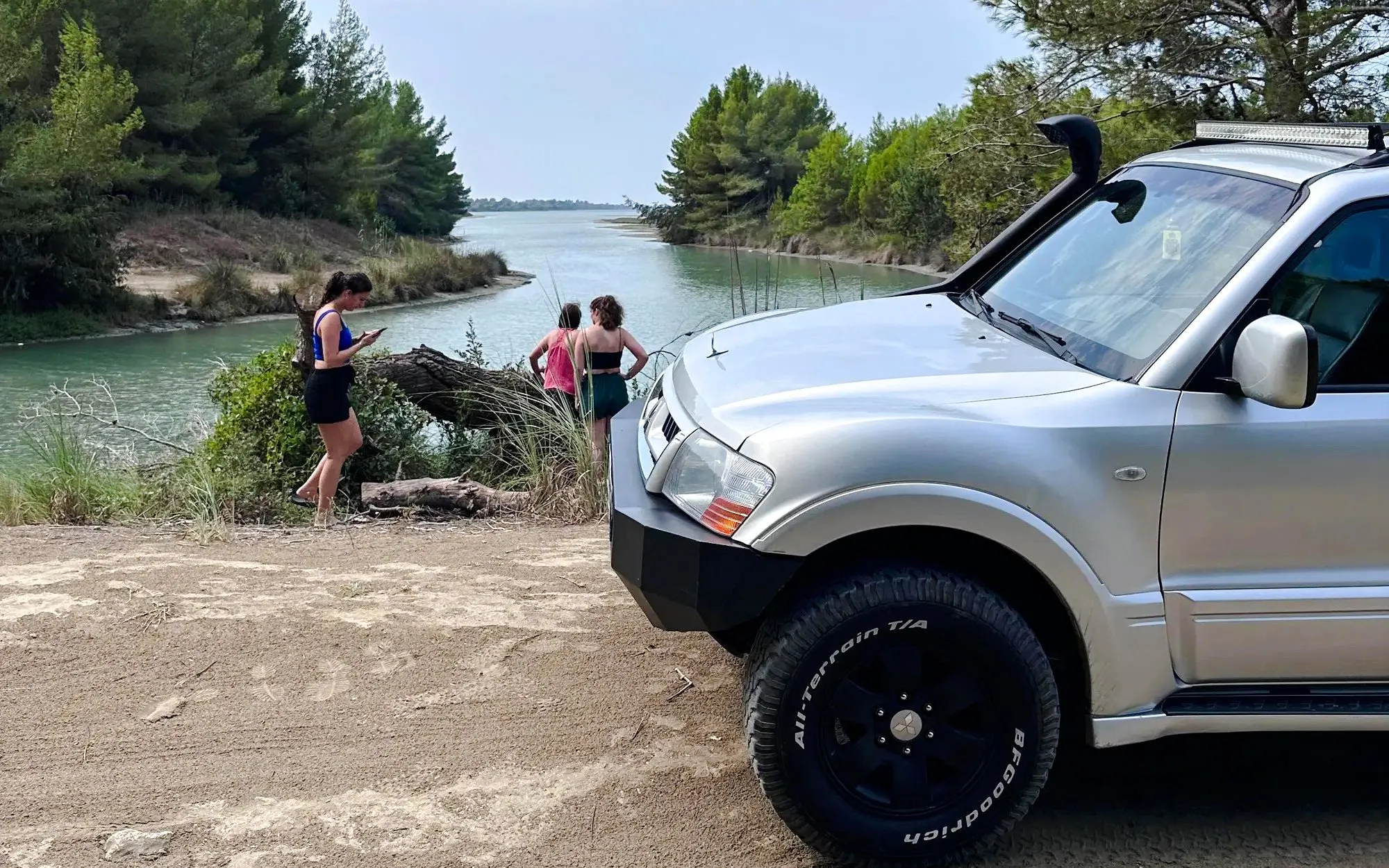 4X4 Jeep parked by Karavasta Lagoon with tourists exploring the scenic waterway.