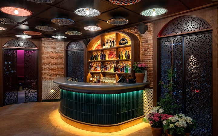 Bar area at Flamenco De Leones Show venue with decorative ceiling and brick walls.
