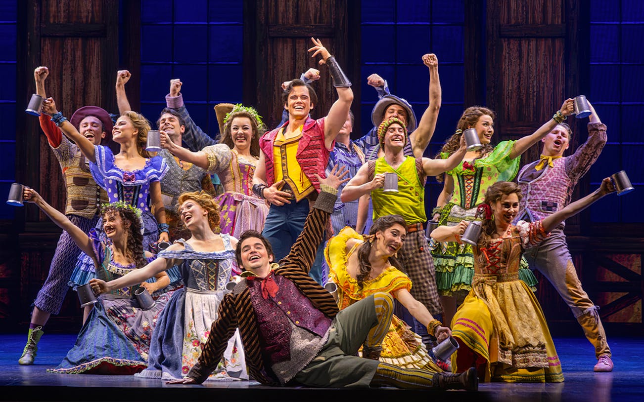 Cast performing a lively tavern scene from Beauty and the Beast musical.