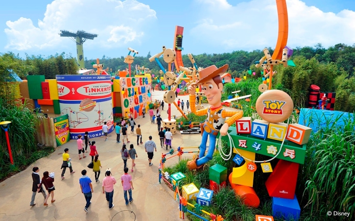 Visitors exploring Toy Story Land with Woody statue at Disneyland Hong Kong.