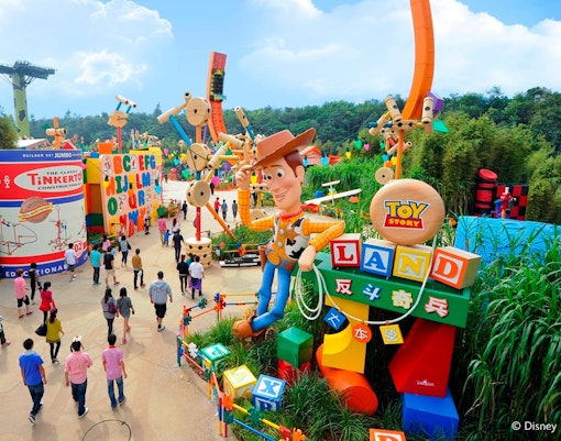 Visitors exploring Toy Story Land with Woody statue at Disneyland Hong Kong.