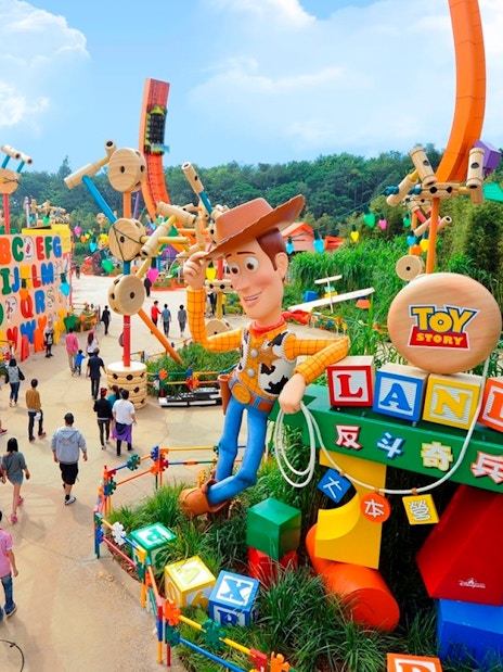 Visitors exploring Toy Story Land with Woody statue at Disneyland Hong Kong.