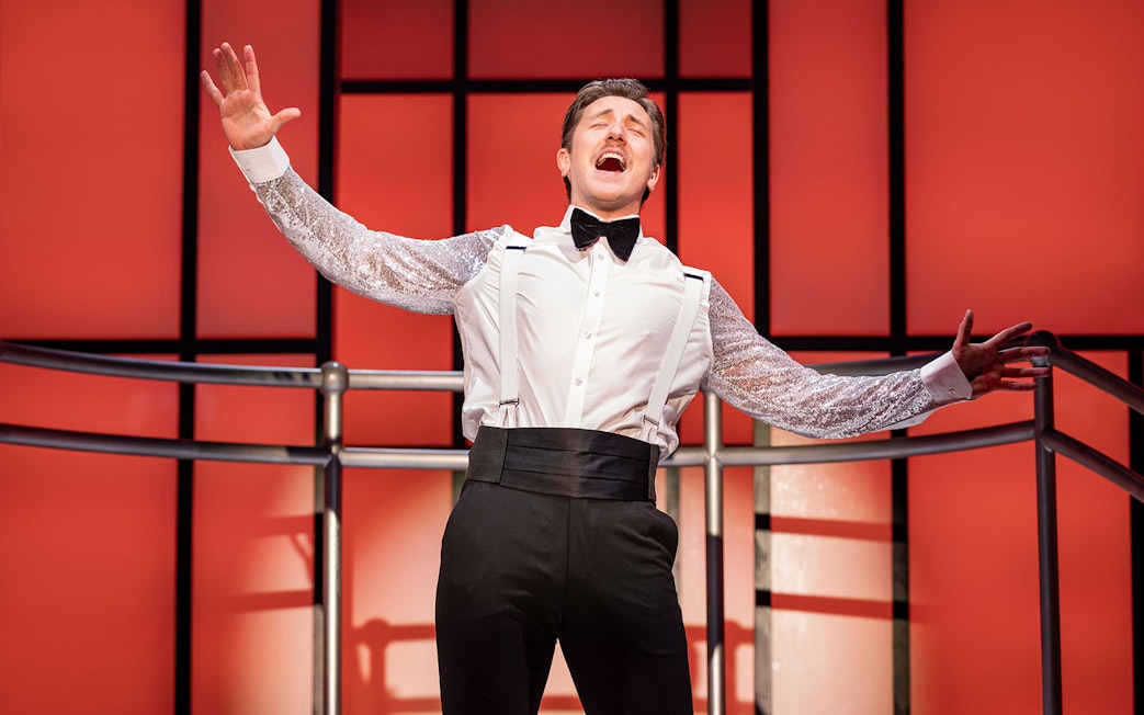 Performer singing on stage during Titanique West End show.