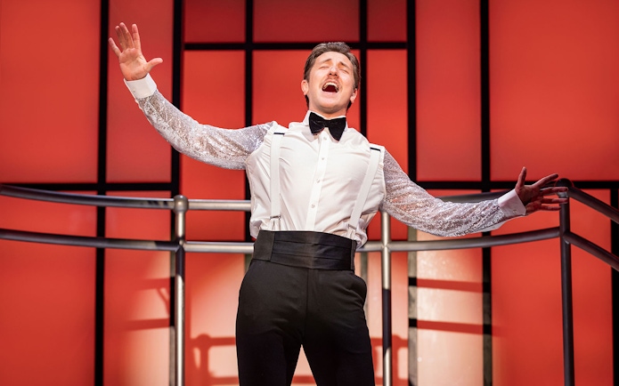 Performer singing on stage during Titanique West End show.