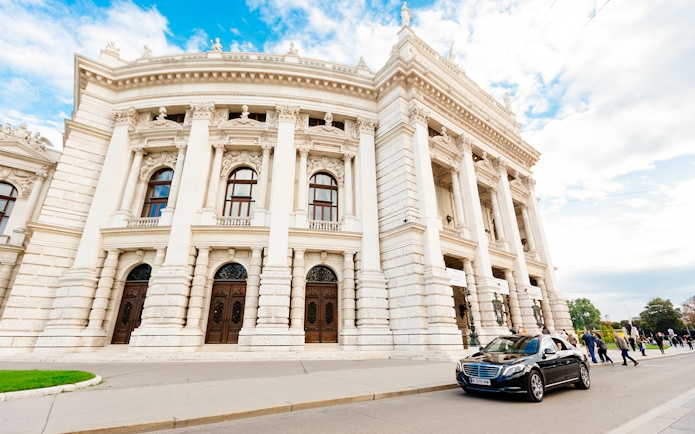 Vienna city tour with view of historic building and passing car.
