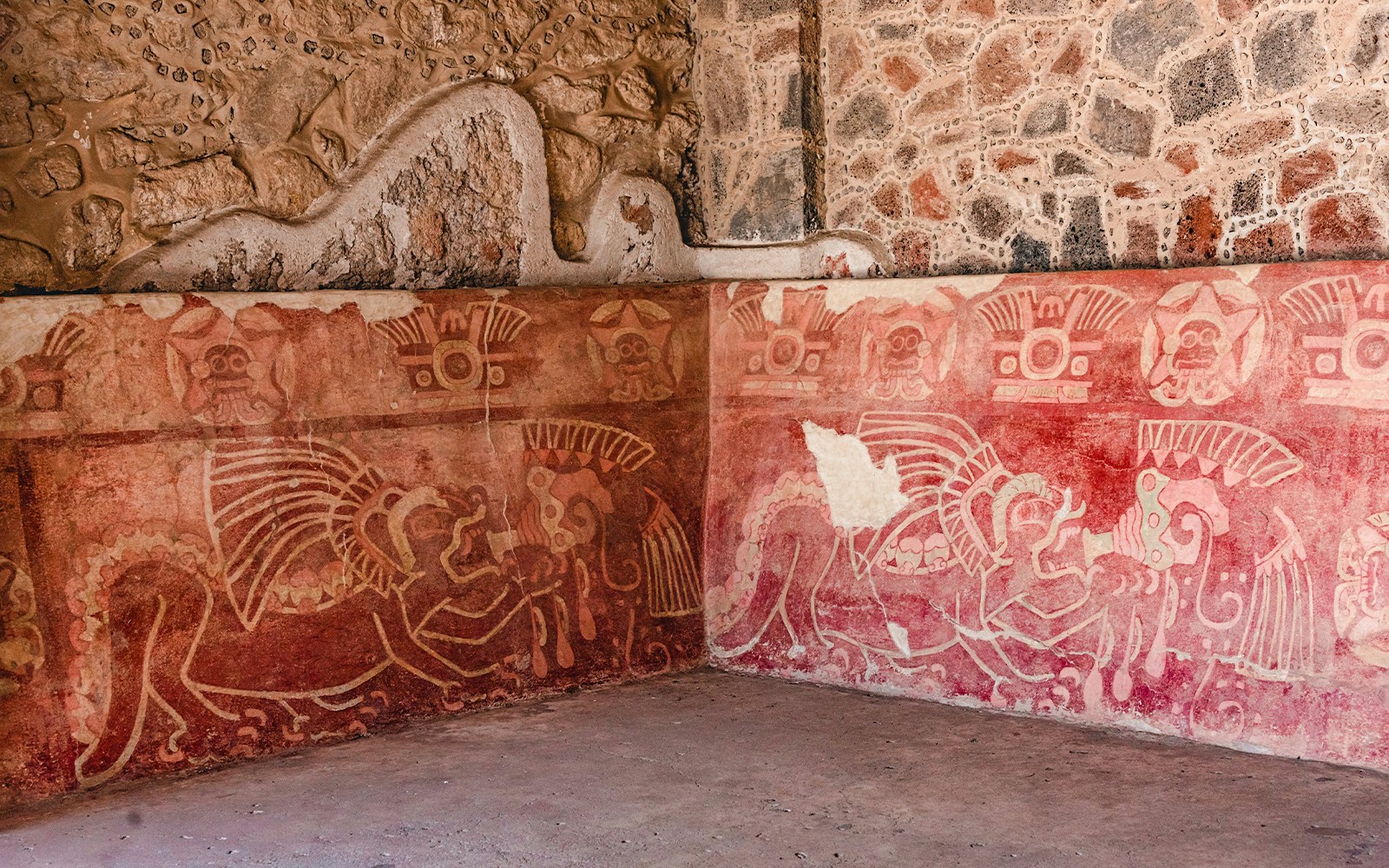 Murals at Palace of the Jaguars showing plumed felines with conch shells and a goggled deity.