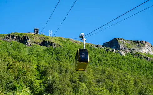 Fjellheisen cable car ascending over green hills in Tromso, Norway.