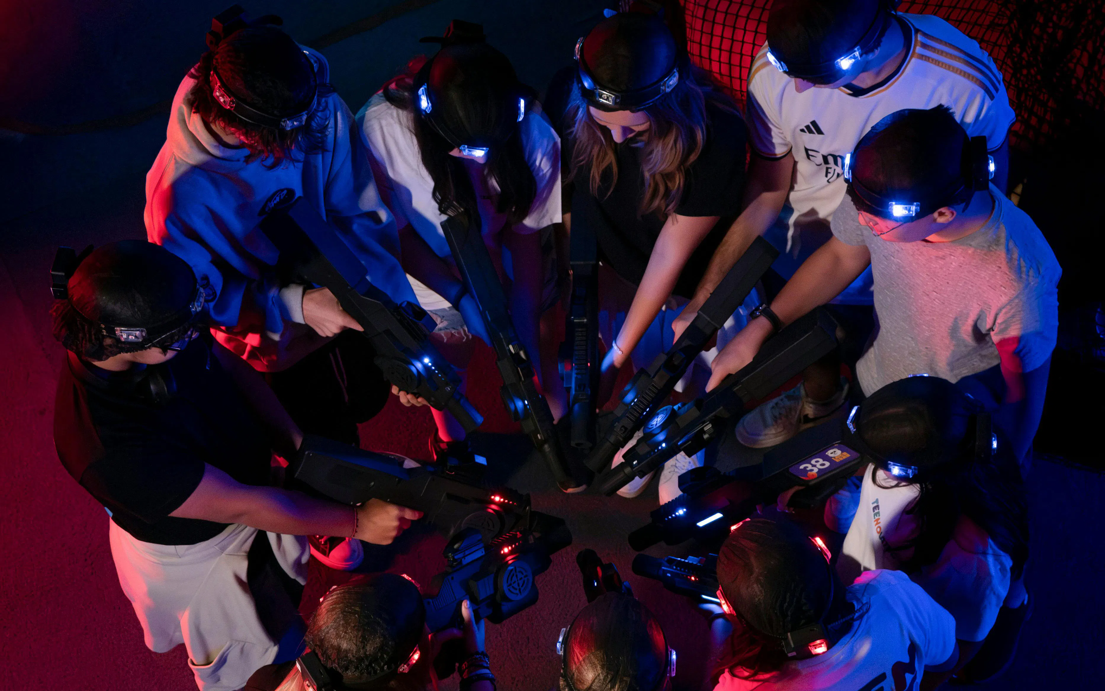 Guests playing laser tag at Loco Bear, Dubai, forming a circle with laser guns.