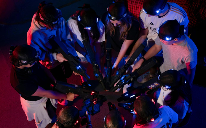 Guests playing laser tag at Loco Bear, Dubai, forming a circle with laser guns.
