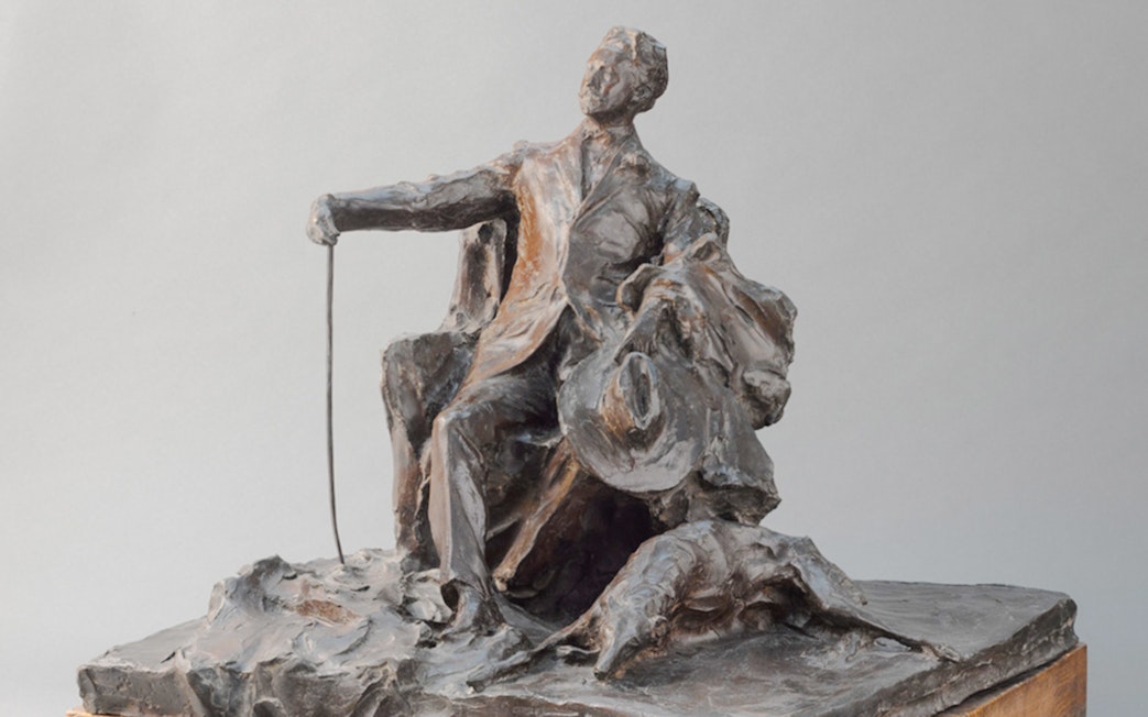 Sculpture by Paul Troubetzkoy depicting Giovanni Segantini seated with a cane and hat.