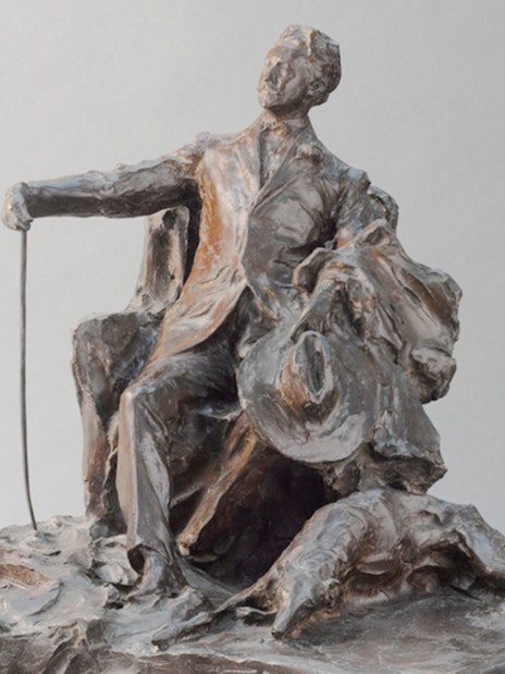 Sculpture by Paul Troubetzkoy depicting Giovanni Segantini seated with a cane and hat.