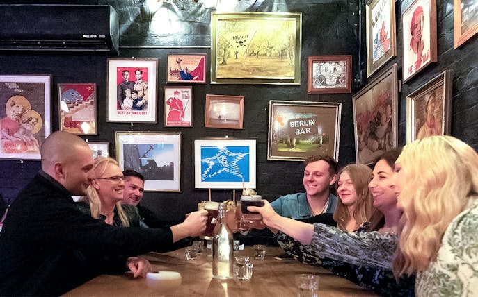 Group enjoying drinks at a hidden bar in Melbourne during a guided cocktail tour.