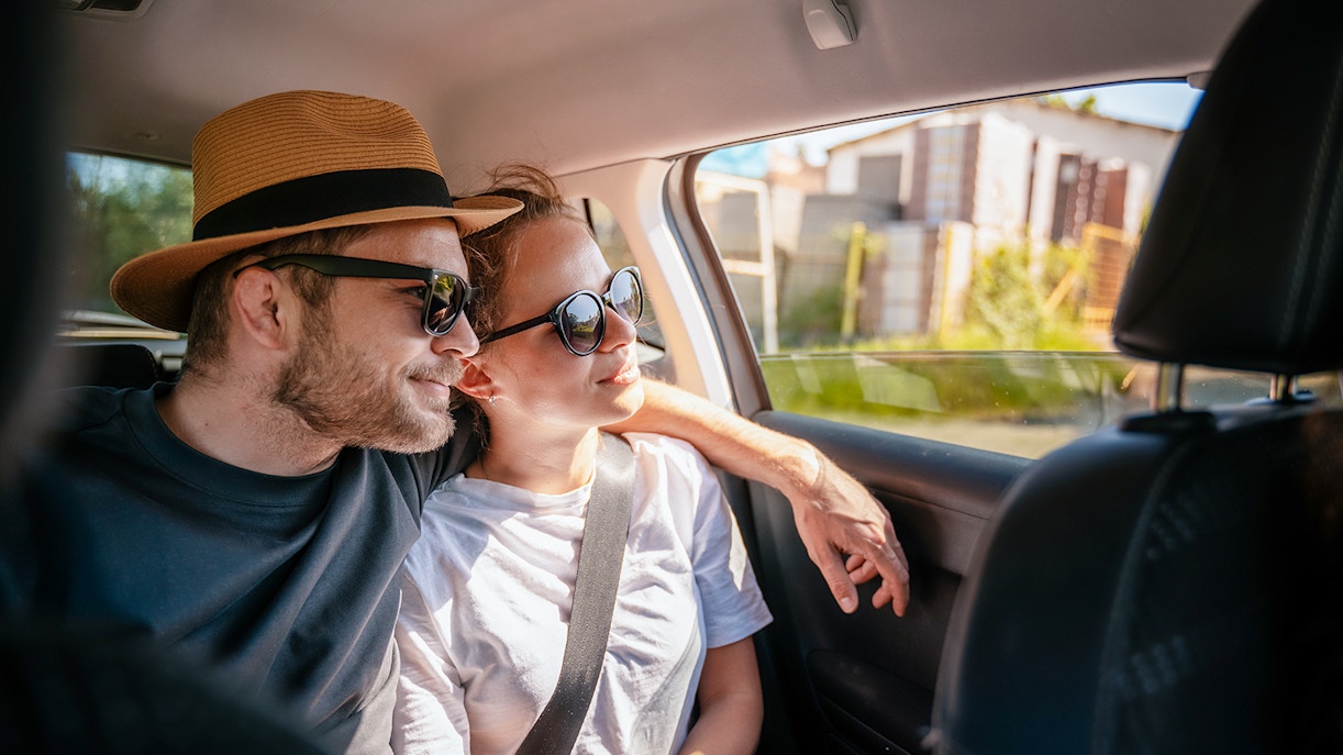 Couple enjoying a car transfer, seated in the backseat.