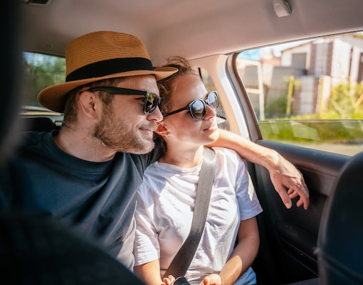 Couple enjoying a car transfer, seated in the backseat.