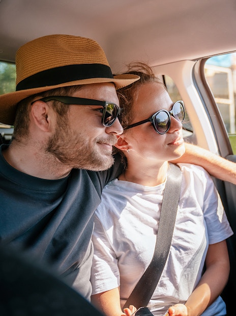 Couple enjoying a car transfer, seated in the backseat.