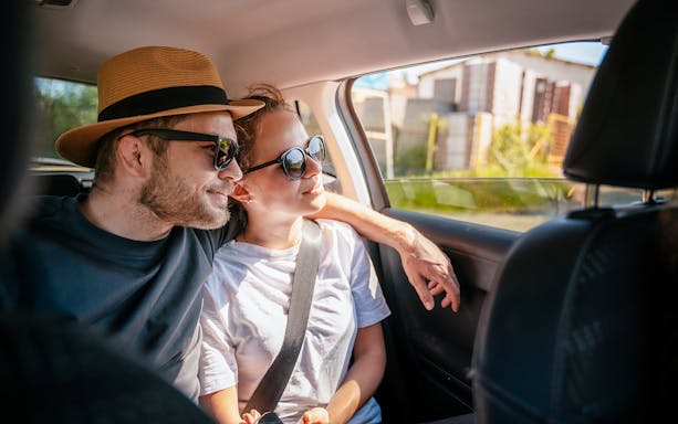 Couple enjoying a car transfer, seated in the backseat.