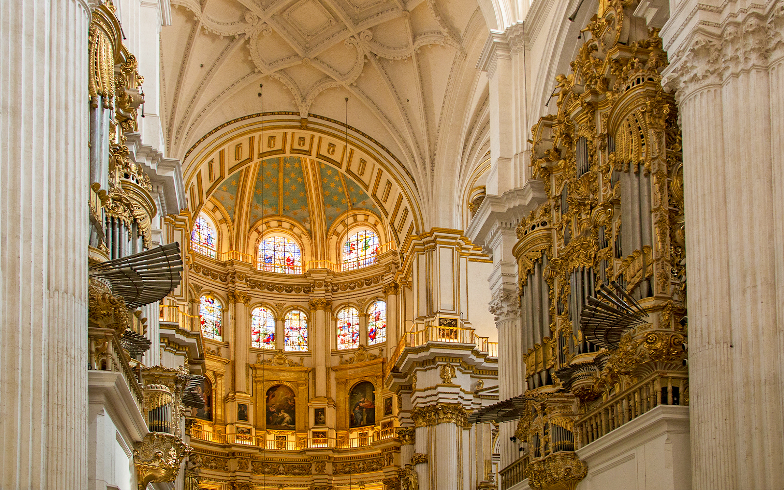 Interior of the Royal Chapel, Granada Cathedral, featuring ornate architecture and stained glass windows.