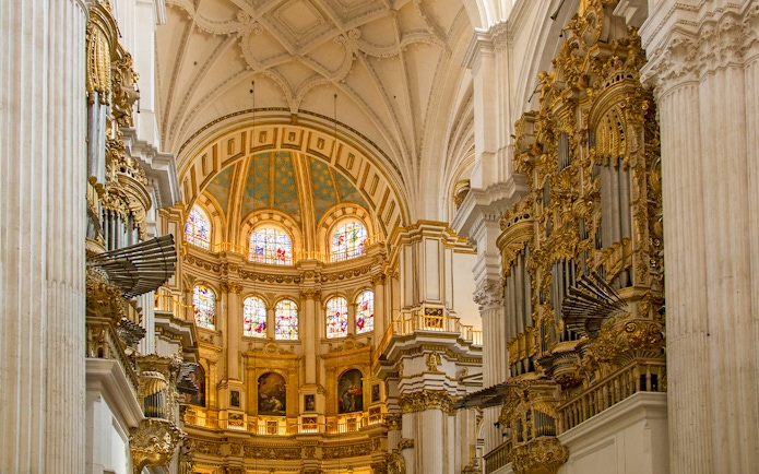 Interior of the Royal Chapel, Granada Cathedral, featuring ornate architecture and stained glass windows.