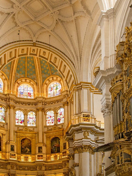 Interior of the Royal Chapel, Granada Cathedral, featuring ornate architecture and stained glass windows.