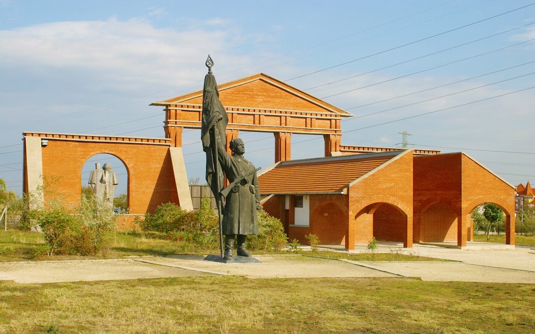 Statue and brick structures at Memento Park, Budapest.
