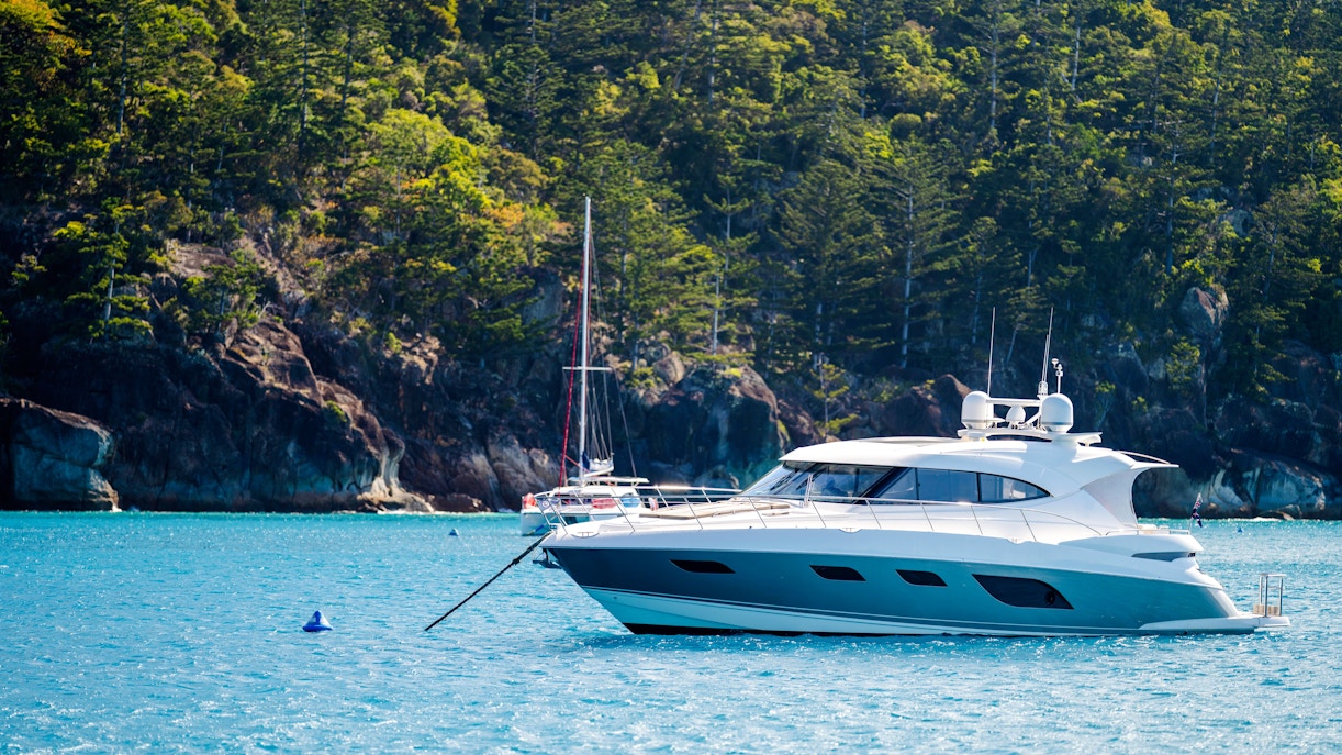 Tourist boats in the Whitsundays, Queensland, Australia, near lush coastline.