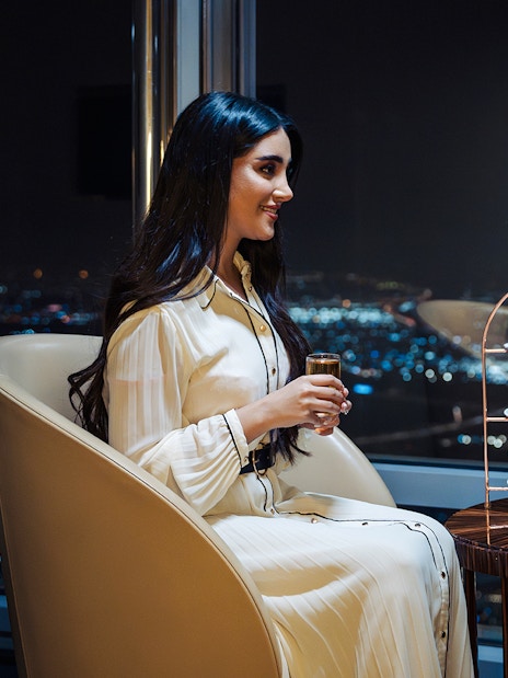 Guests enjoying drinks and desserts at Burj Khalifa Level 152 lounge with city view.