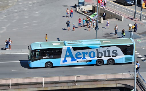 Aerobus in Barcelona city center with tourists nearby.