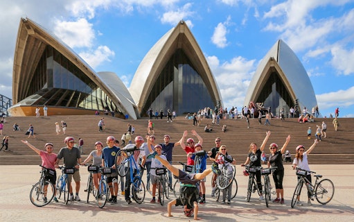 Group of cyclists with Bonza Bike Tours in front of Sydney Opera House.