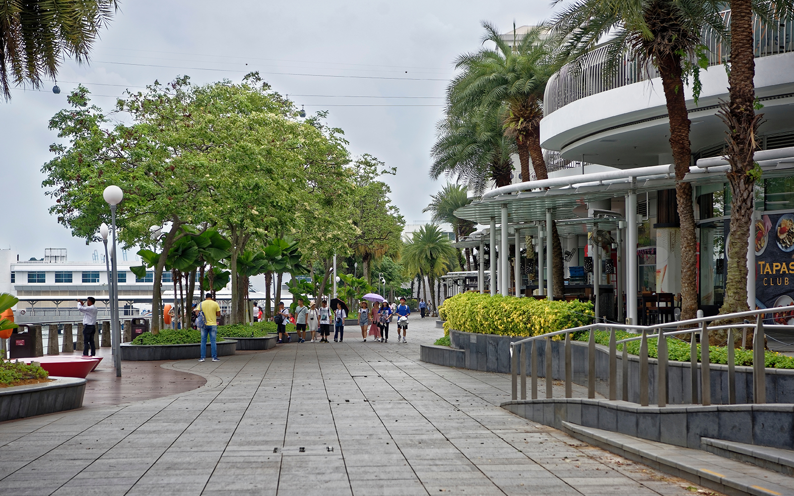 VivoCity shopping mall exterior in Singapore with people walking and waterfront view.