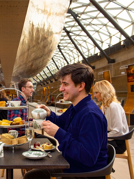Guests enjoying afternoon tea under the Cutty Sark in London.